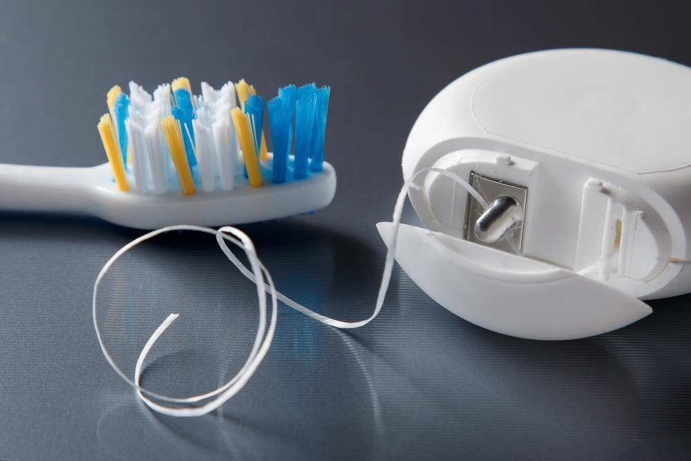 Floss and tooth brush. Flossing is another way of how to get rid of plaque 